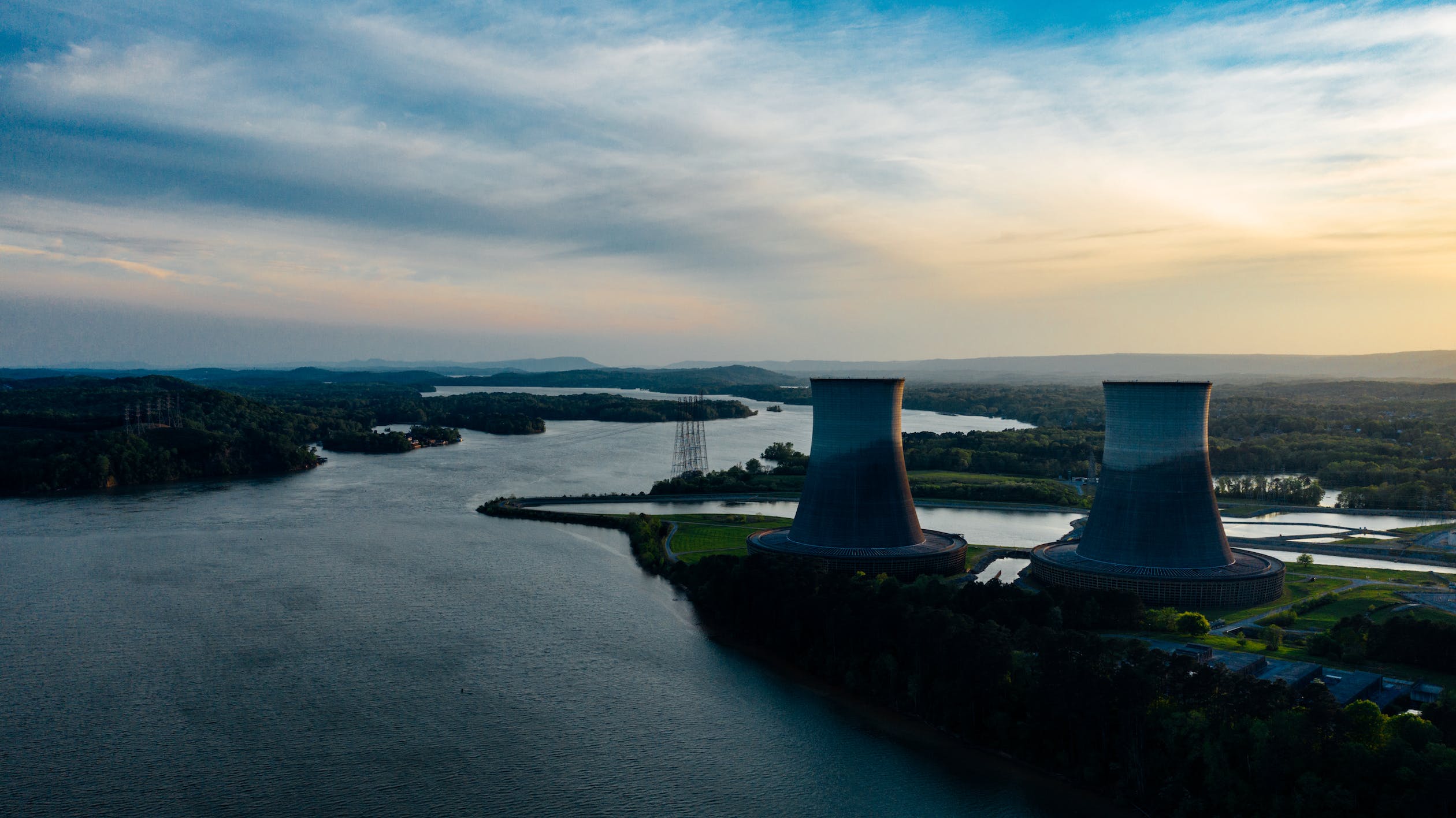 A coal power station across a wide river at dusk