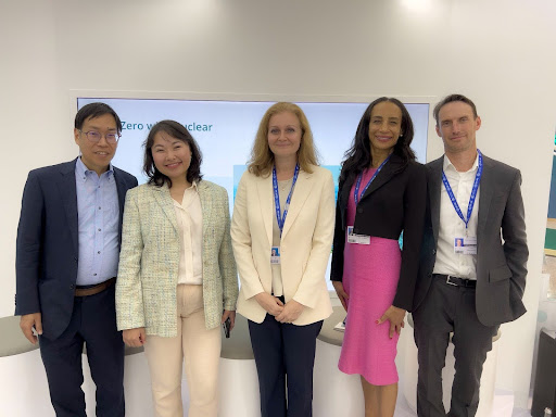 Five panelists standing together after the COP28 session on climate financing for nuclear
