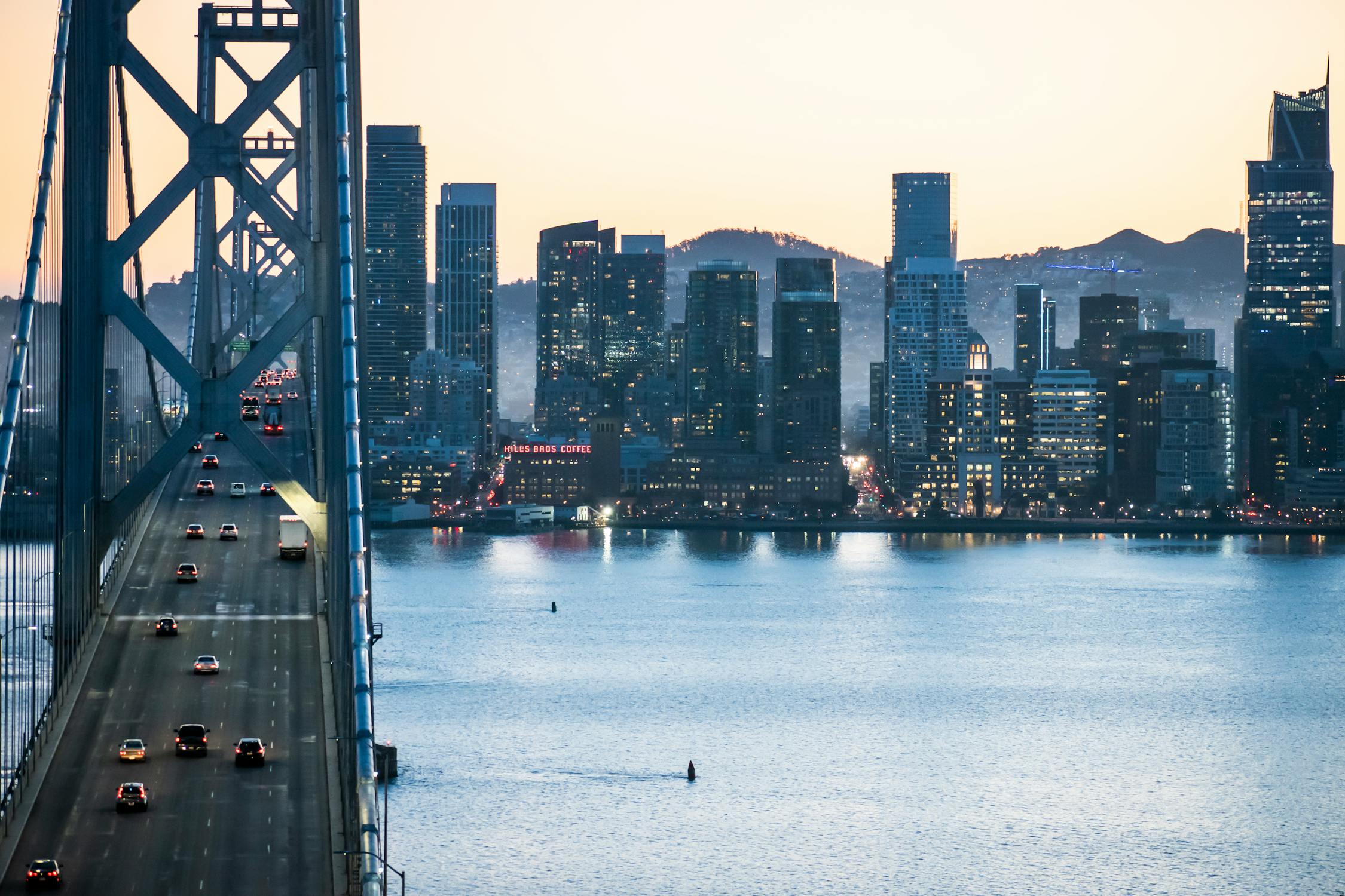 The Bay Bridge at dusk with the San Francisco skyline behind it
