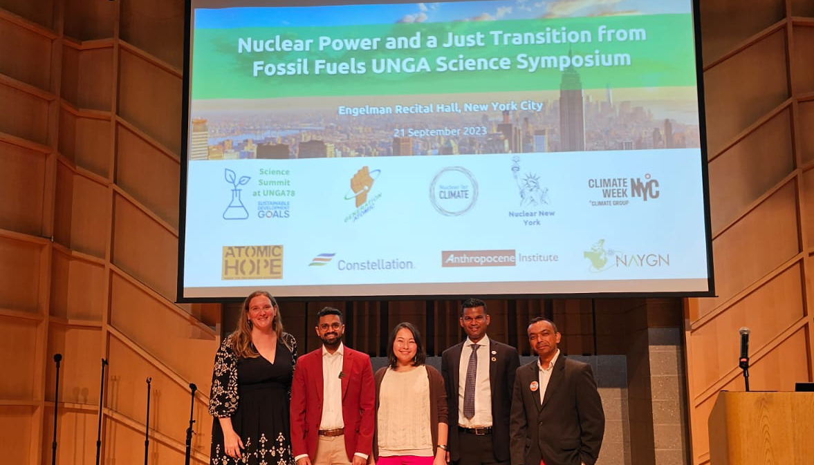 Speakers lined up on stage in front of a screen reading Nuclear Power and a Just Transition from Fossil Fuels
