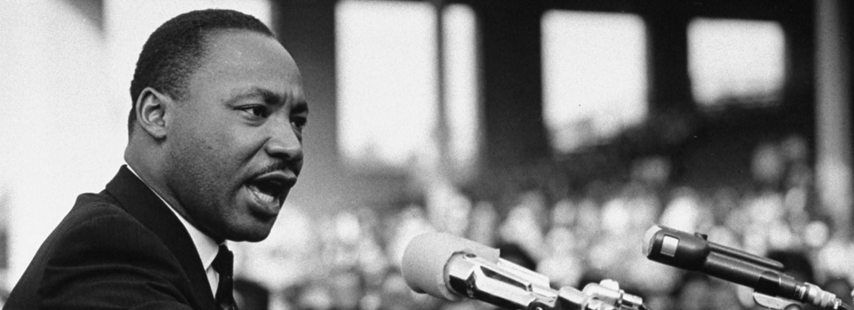 Martin Luther King Jr. speaking at a bank of microphones