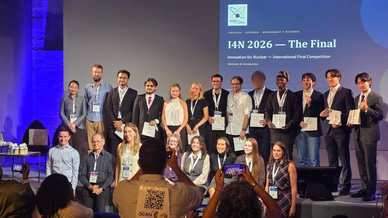 Finalists, judges and organizers of the I4N 2026 final standing on stage in Avignon in front of a screen reading I4N 2026 — The Final