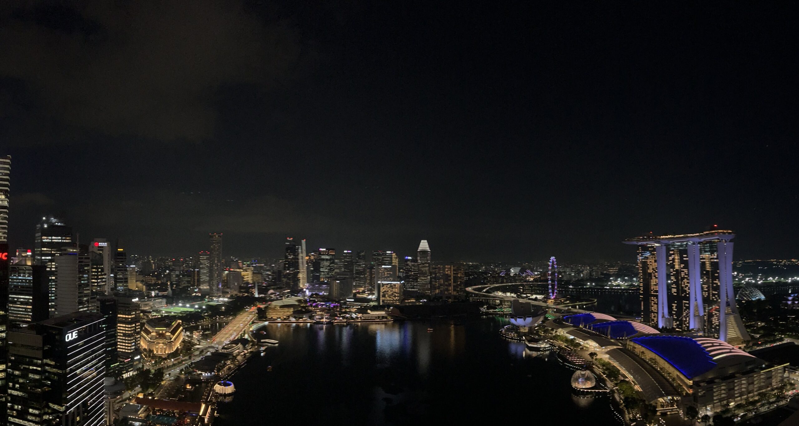The Singapore skyline at night across Marina Bay, with Marina Bay Sands lit on the right