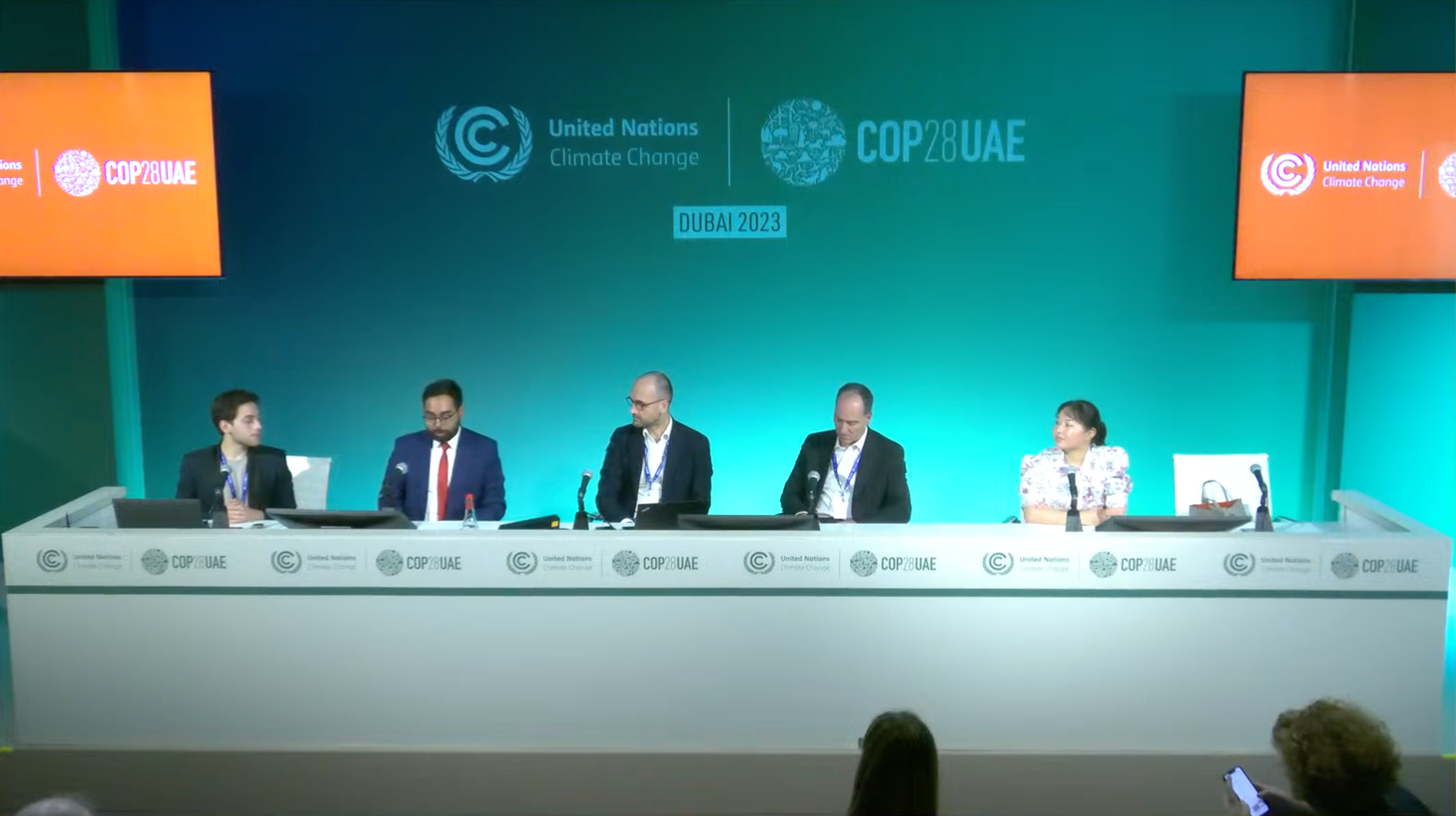 Panelists seated at a table in a COP28 pavilion in front of UNFCCC branding