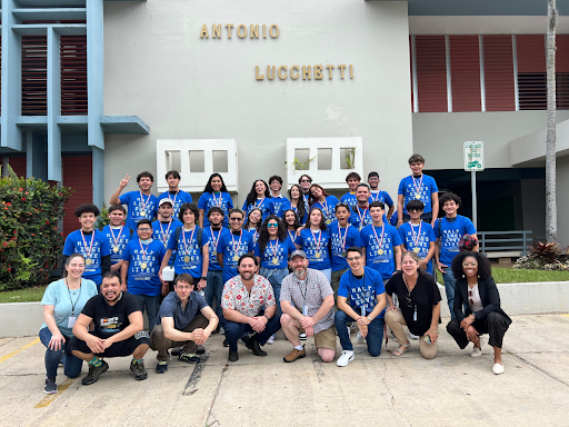 Bootcamp students and instructors in matching blue shirts posed outside the Antonio Lucchetti building